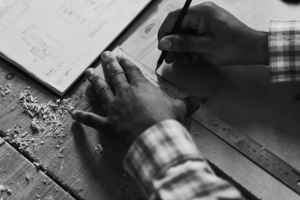 Imagem de mão de homem medindo e desenhando com uma régua